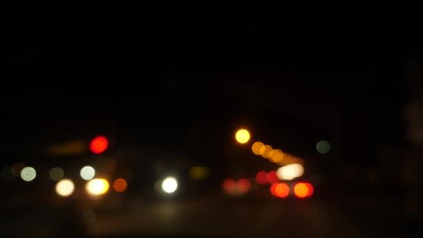 's Nachts rijden. wazige auto 's in de stad. Verlicht voorruit met wazig stadsverkeer op de straten. 4k — Stockvideo