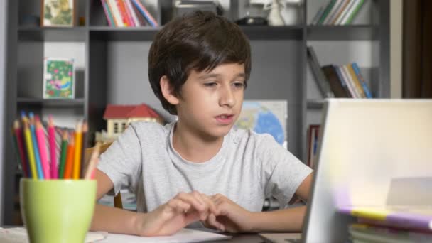 Concept of online learning. the child is enrolled in an online school. boy doing homework with laptop. 4k, slow motion — Stock Video