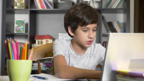 Conceito de aprendizagem online. a criança está matriculada em uma escola online. menino fazendo lição de casa com laptop. 4k, câmera lenta — Vídeo de Stock