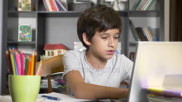 Concetto di apprendimento online. il bambino è iscritto in una scuola online. Ragazzo che fa i compiti con il portatile. 4k, rallentatore — Video Stock