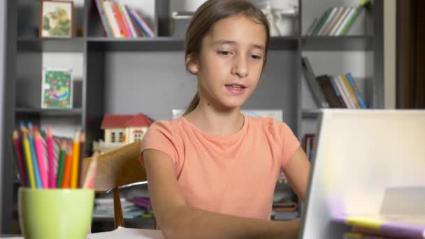 Concepto de aprendizaje en línea. el niño está inscrito en una escuela en línea. chica haciendo los deberes con el portátil. 4k, cámara lenta — Vídeo de stock