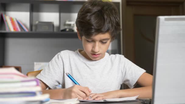 Concepto de aprendizaje en línea. el niño está inscrito en una escuela en línea. chico haciendo la tarea con el portátil. 4k, cámara lenta — Vídeos de Stock