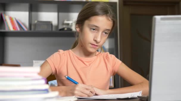 Concepto de aprendizaje en línea. el niño está inscrito en una escuela en línea. chica haciendo los deberes con el portátil. 4k, cámara lenta — Vídeos de Stock