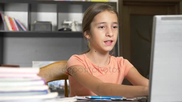 Online tanulás fogalmának. a gyerek beiratkozott egy online iskola. a lány csinál házi feladatot a laptop. 4k, lassú mozgás — Stock videók