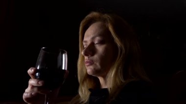 Üzgün, güzel bir kadın geceleri şarap içme. yakın çekim, 4k, ağır çekim.