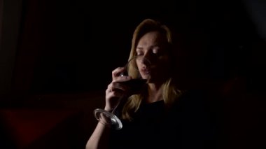 Üzgün, güzel bir kadın geceleri şarap içme. yakın çekim, 4k, ağır çekim.