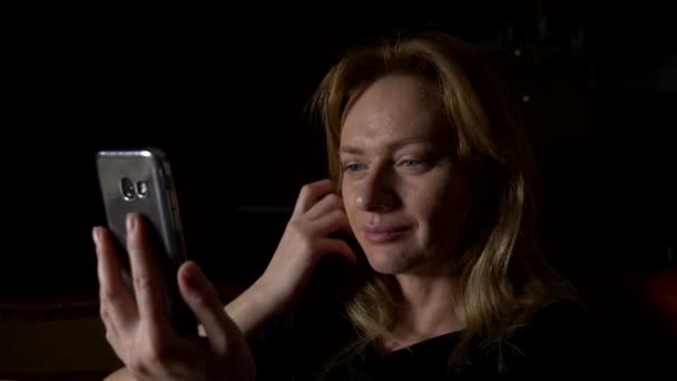 Женщина пользуется мобильным телефоном ночью. Закрывай, копируй пространство. 4k, slow motion — стоковое видео