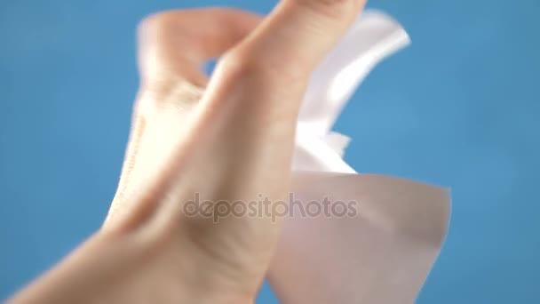 Mains déchirer feuille de papier, gros plan sur un fond turquoise. 4k, au ralenti — Video