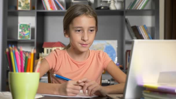 Koncepcja kształcenia online. dziecko jest zapisany w szkole online. dziewczyna robi pracę domową z laptopa. 4k, zwolnionym tempie — Wideo stockowe