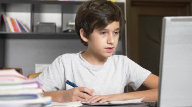 çevrimiçi öğrenme kavramı. Çocuk bir online okullarından birine kaydoldu. dizüstü bilgisayar ile ödev çocuk. 4k, ağır çekim