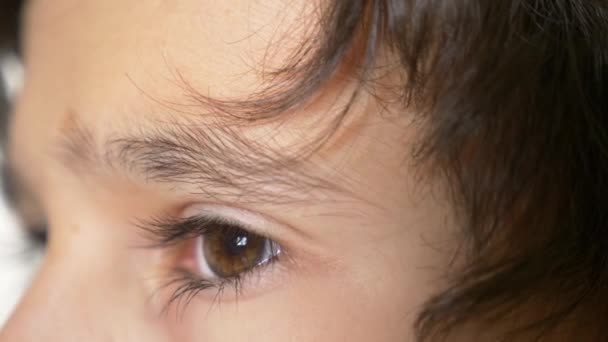 Een jongens bruine ogen met lange zwarte wimpers. 4 k, slow motion, close-up — Stockvideo
