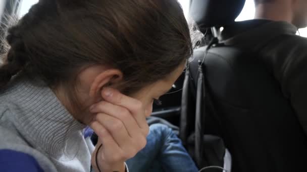4k, rallenta. fratello e sorella gemelli, cavalcare sul sedile posteriore della macchina e ascoltare musica nelle cuffie . — Video Stock