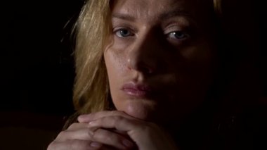 güzel bir genç kadının siyah arka plan üzerine dalgın hüzünlü kadın portre. 4 k, yakın çekim, ağır çekim