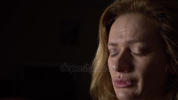 Close-up, mulher triste em um fundo escuro. 4k, câmera lenta — Vídeo de Stock