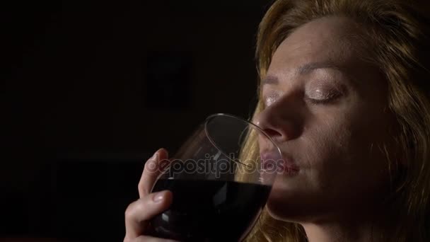 O femeie tristă şi frumoasă bea vin noaptea. close-up, 4k, slow-motion . — Videoclip de stoc
