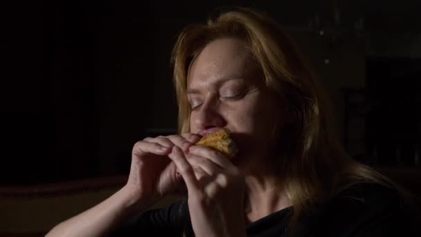 Женщина по ночам ест булочки. концепция расстройства питания. 4k, slow motion — стоковое видео