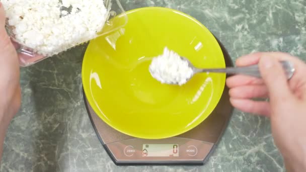 Someone measures cottage cheese in electronic form in the kitchen. 4k, — Stock Video