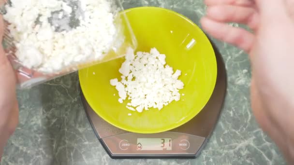 Någon mäter keso i elektronisk form i köket. 4k, — Stockvideo