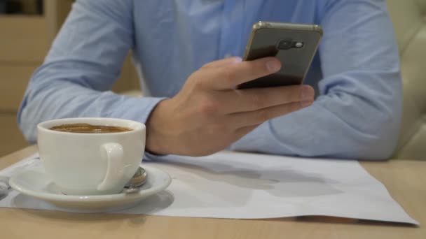 Чоловік входить в повідомлення за допомогою мобільного телефону в кав'ярні. Крупним планом. 4-кілометровий — стокове відео