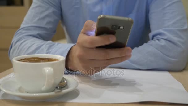 Man invoeren van een bericht met behulp van een mobiele telefoon in een koffiehuis. Close-Up. 4k — Stockvideo