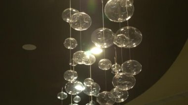 lambaları yakın çekim. Kristal modern avize ayrıntılı arka plan. Kabarcıklar şeklinde lambaları yanıp sönen yansıma parlayan bir asılı. Ağır çekim. 4k