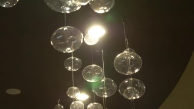 lambaları yakın çekim. Kristal modern avize ayrıntılı arka plan. Kabarcıklar şeklinde lambaları yanıp sönen yansıma parlayan bir asılı. Ağır çekim. 4k
