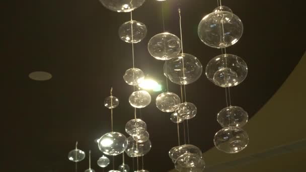 Lamps close-up. Crystal modern chandelier detail background. Hanging lamps in the form of bubbles with a flashing shining reflection. Slow motion. 4k — Stock Video