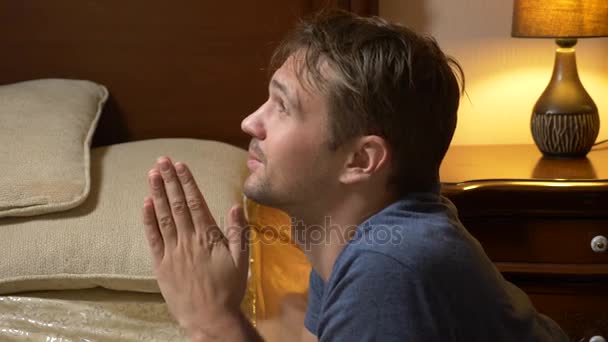 Ο νεαρός προσεύχεται πριν πάτε για ύπνο. 4k — Αρχείο Βίντεο