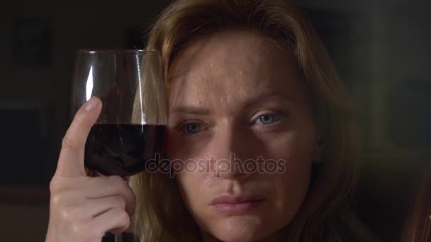 Sad, beautiful woman drinking wine at night. close-up, 4k, slow-motion. — Stock Video