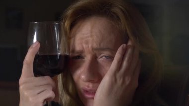 Üzgün, güzel bir kadın geceleri şarap içme. yakın çekim, 4k, ağır çekim.