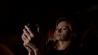 Üzgün, güzel bir kadın geceleri şarap içme. yakın çekim, 4k, ağır çekim.