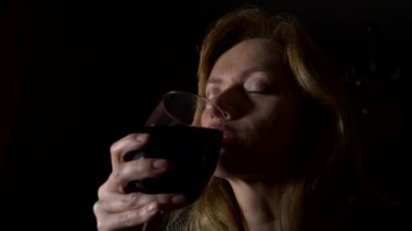 Üzgün, güzel bir kadın geceleri şarap içme. yakın çekim, 4k, ağır çekim.
