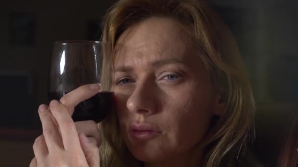 Грустная, красивая женщина пьет вино по ночам. крупный план, 4k, замедленная съемка . — стоковое видео