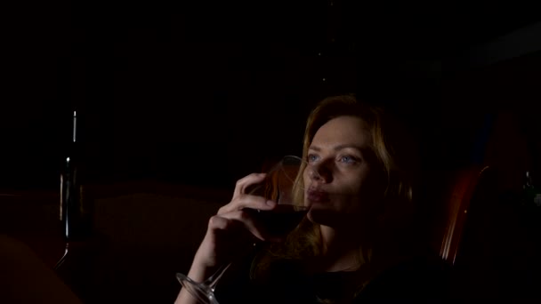 Triste, hermosa mujer bebiendo vino por la noche. primer plano, 4k, cámara lenta . — Vídeo de stock
