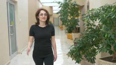 Kameraya bakarak ve gülümseyen güzel kız. Gözlüklü kadın. 4k