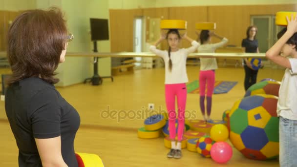 Turnen mit einem Kinderlehrer im Sportunterricht. Beschäftigung mit Bällen, 4k — Stockvideo