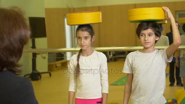 Turnen mit einem Kinderlehrer im Sportunterricht. Beschäftigung mit Bällen, 4k — Stockvideo