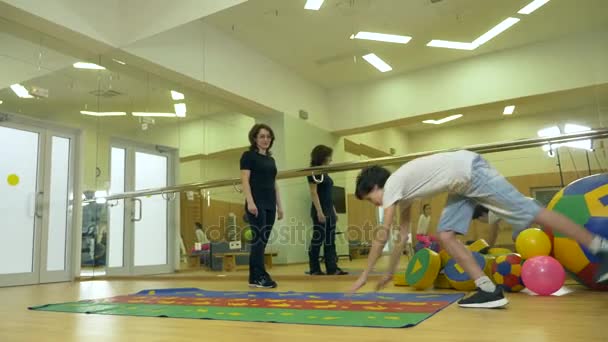 Senam dengan instruktur anak-anak dalam pendidikan fisik. pekerjaan dengan bola, 4k — Stok Video