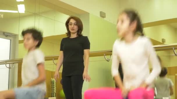Turnen met een instructeur van de childrens in lichamelijke opvoeding. bezetting met ballen, 4k — Stockvideo