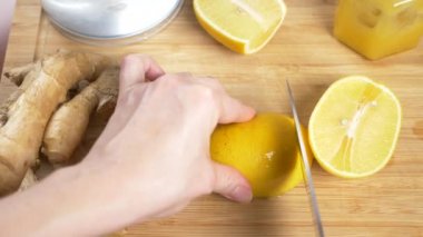 eller düşük narenciye zencefil kökü ile el yapımı yapılan bir içki için bir bıçak-limon ile kesmek. 4k, ağır çekim
