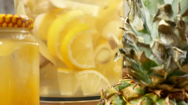 Ktoś robi ręcznie drinka z cytryn, korzeń imbiru i ananasa. 4k — Wideo stockowe