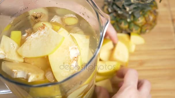 Quelqu'un fait une boisson faite à la main à partir de citrons, de racine de gingembre et d'ananas. 4k, au ralenti — Video