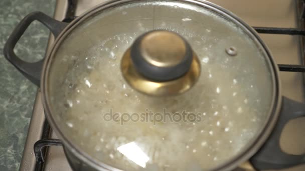 Preparación de arroz integral. Agua hirviendo con cereal en una cacerola en la estufa. 4k, cámara lenta — Vídeos de Stock