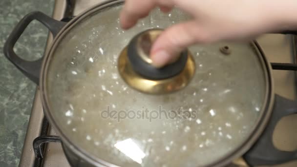 Preparación de arroz integral. Agua hirviendo con cereal en una cacerola en la estufa. 4k, cámara lenta — Vídeo de stock