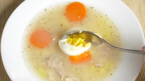 Valaki eszik a csirke tojás egy tányér leves. 4k, lassú mozgás — Stock videók