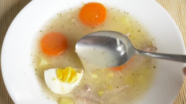 Κάποιος τρώει σούπα κοτόπουλου με αυγό από ένα πιάτο. 4k, αργή κίνηση — Αρχείο Βίντεο