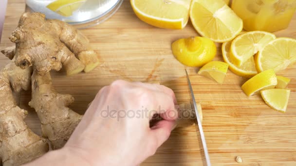 Ženské ruce nakrájíme na kousky zázvor kořen pro nápoj vyrobený z citrusů ručně s ginger. 4k — Stock video