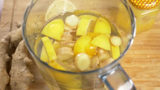 Someone makes a handmade drink from lemons, ginger root and pineapple. 4k — Stock Video