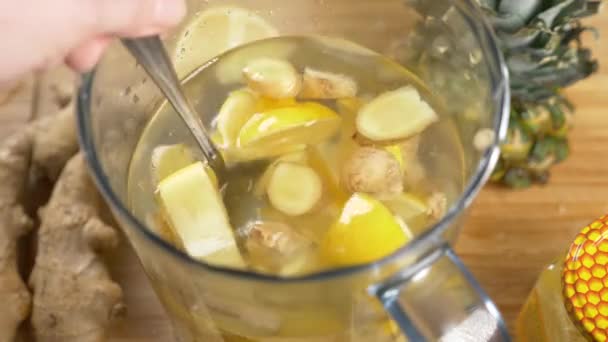 Someone makes a handmade drink from lemons, ginger root and pineapple. 4k — Stock Video