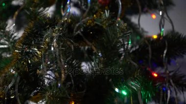 Bir şekilde dekore edilmiş ve ışıklı Noel ağacı güzel parlak bir top ile çok renkli ışıklar bir Garland bulanık. 4k, ağır çekim